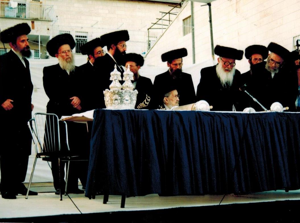 הרב בוימיל קורא בתורה לימין הנתיבות שלום זיע''א נראה משמאל כ''ק אדמו''ר שליט''א מסלונים.jpg